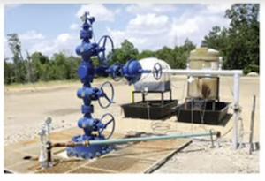 Figure 2.4: Completed well with blue wellhead and supporting processing infrastructure. Source: Petroleum Engineering Youtube Video 